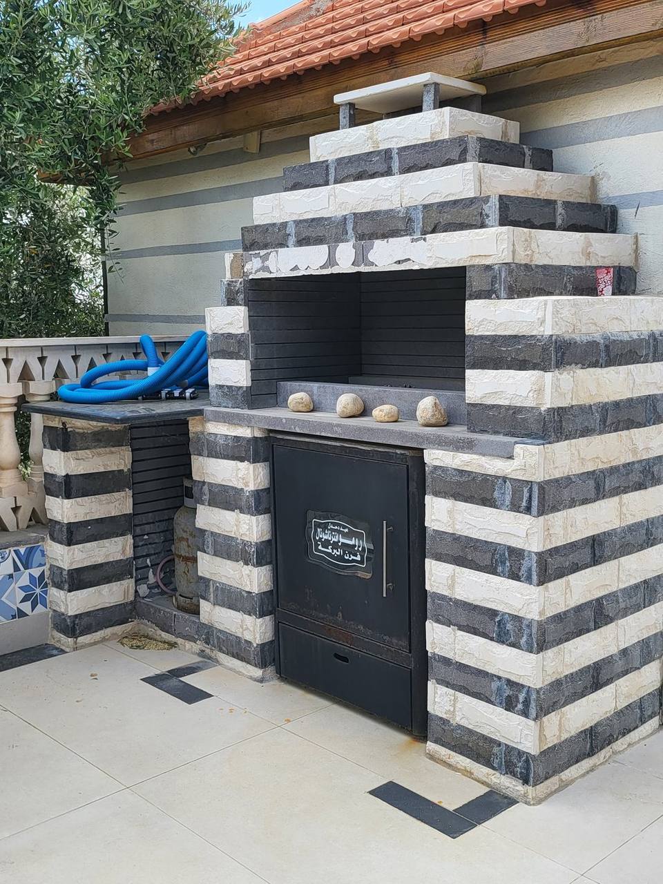 Bespoke outdoor BBQ and pizza oven — striped stone masonry