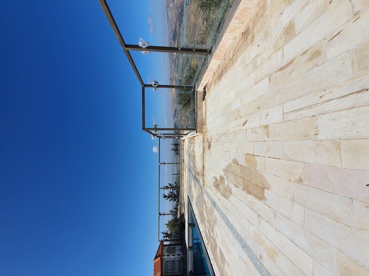 Pool terrace surface before renovation — bare stone with water staining and drainage failures