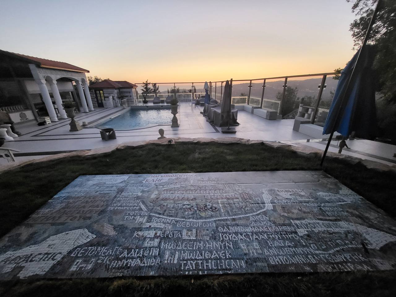 Sunset panorama — mosaic map foreground with infinity pool terrace