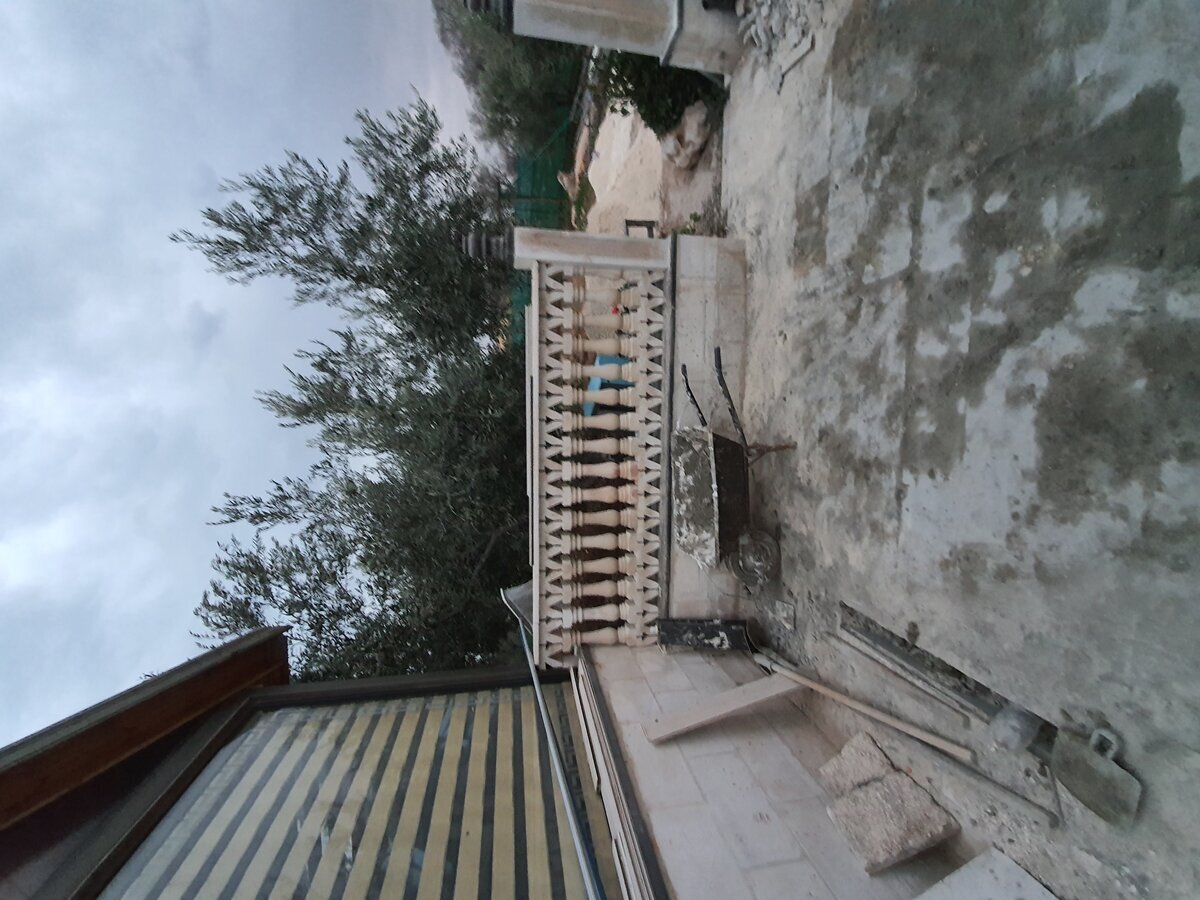 Balcony terrace during works — bare concrete screed, balustrade base course being laid