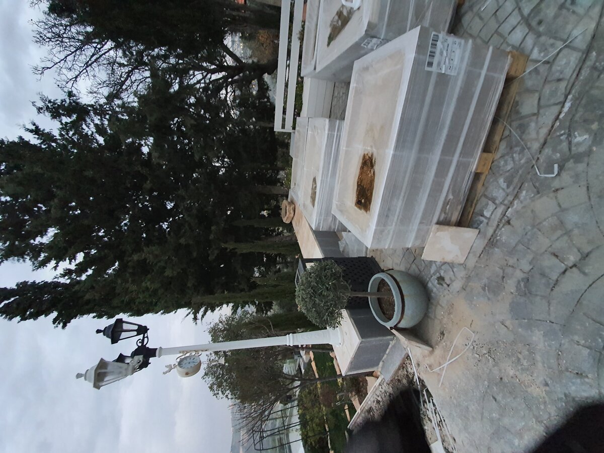 Stone paving slabs delivered on pallets — staged on terrace ready for installation