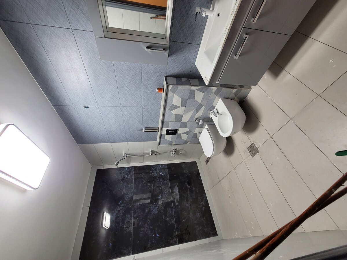 Master bathroom delivered — large-format tiling, wall-hung WC and vanity, fully snagged