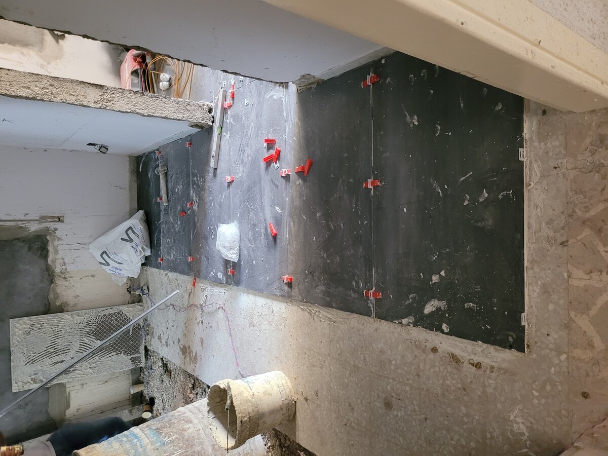 Master bathroom — large-format stone-effect tiling in progress