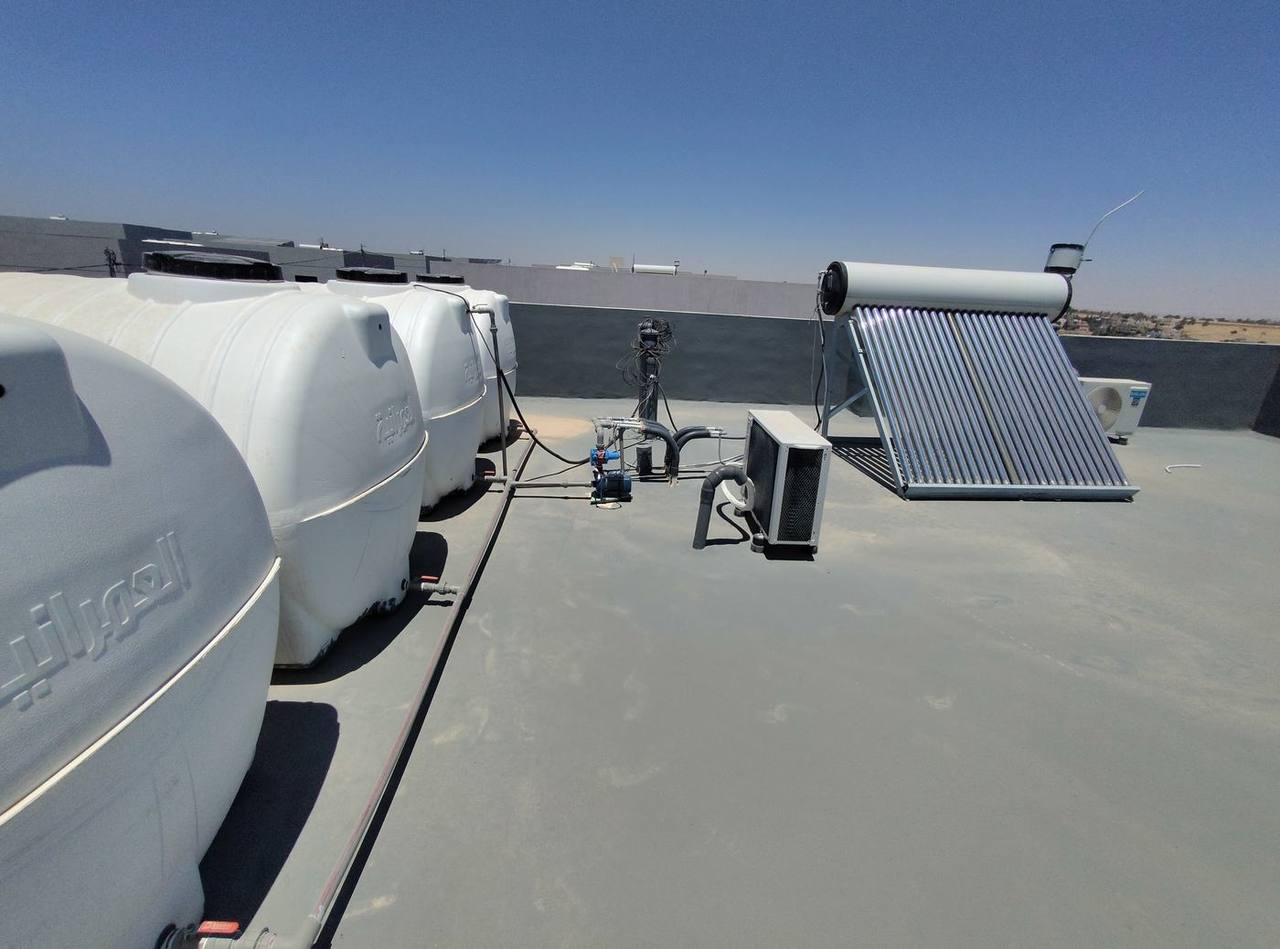 Roof waterproofing works — water tanks, solar panel and membrane being applied
